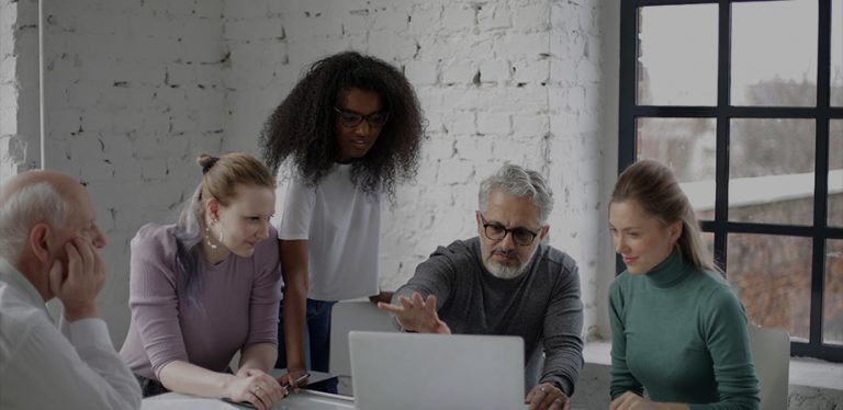 diversas pessoas olhando para um notebook