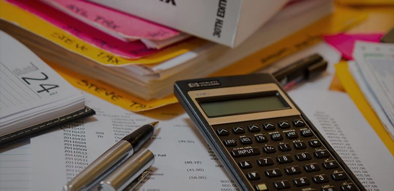 mesa cheia de contas e uma calculadora